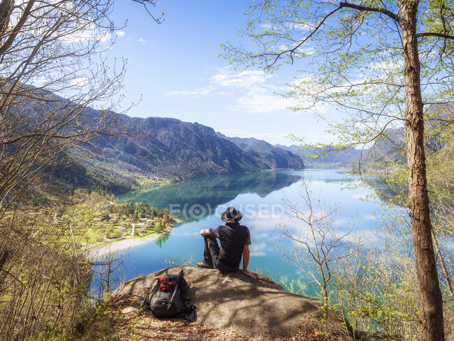 Italy, Lombardy, spring at Lake Idro, hiker sitting on observation point — Stock Photo