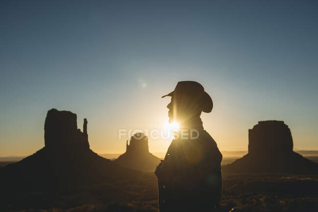 США, Utah, Monument Valley, силуэт человека в шапке-ушанке на рассвете — стоковое фото