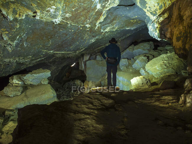España, País Vasco, Euskadi, hombre mayor viendo rocas en la cueva de Baltzola - foto de stock