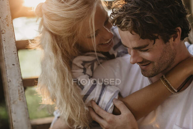 Feliz jovem casal abraçando na velha escadaria ao pôr do sol — Fotografia de Stock