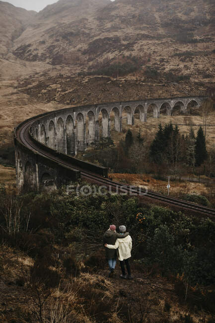 Reino Unido, Escocia, Highland, Glenfinnan Viaduct, vista trasera de las amigas mirando a la vista - foto de stock