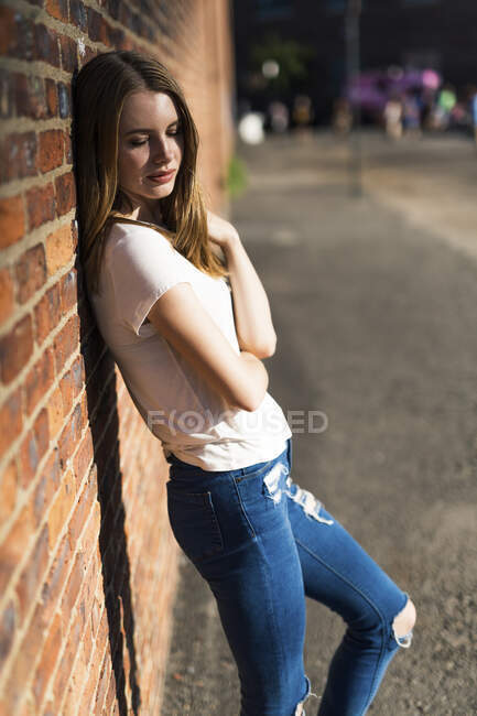 Young woman leaning on brick wall in New York City — Stock Photo