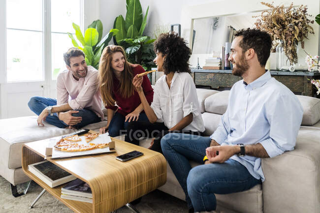 Freinds divertirsi, mangiare pizza insieme, seduti sul divano — Foto stock