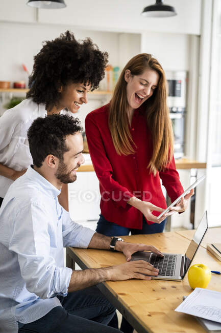 Amigos trabajando juntos en un proyecto en su oficina loft - foto de stock