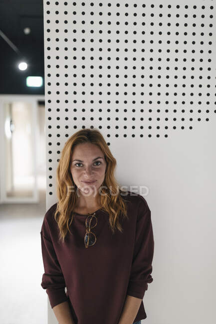 Porträt einer lächelnden jungen Frau an einer Wand — Stockfoto