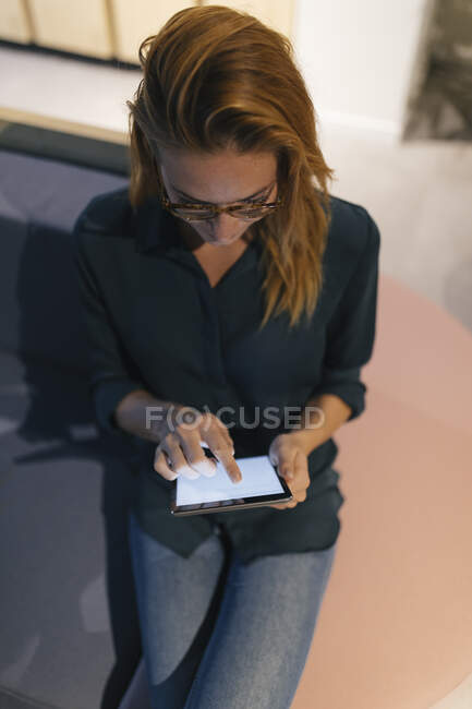 Geschäftsfrau sitzt mit Tablet auf Couch — Stockfoto