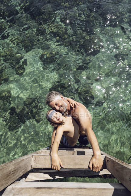 Indonésia, Parque Nacional de Komodo, pai feliz e filha abraçando no mar — Fotografia de Stock