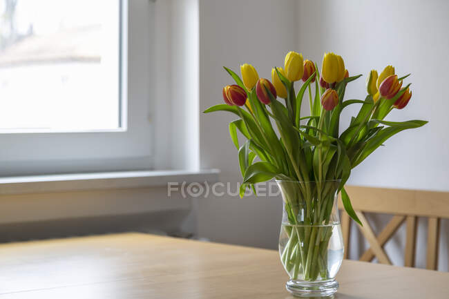 Strauss aus roten und gelben Tulpen auf dem Esstisch — Stockfoto