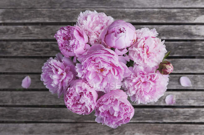 Ramo de peonía rosa en la mesa de jardín - foto de stock
