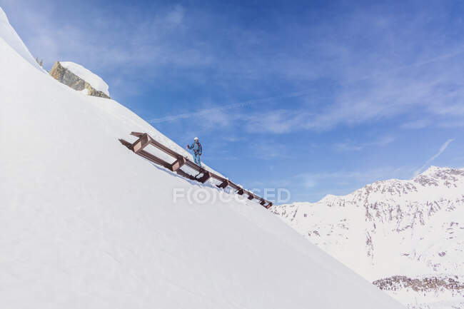Austria, Tirol, Galtuer, esquiador de pie sobre una protección contra avalanchas - foto de stock