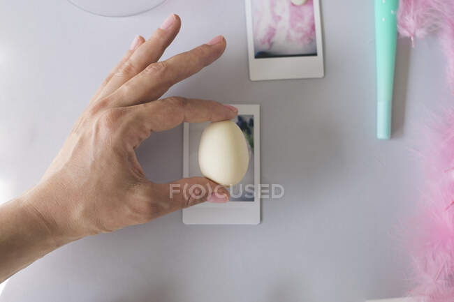 Hand hält ein Ei gegen Polaroid-Bilderrahmen — Stockfoto