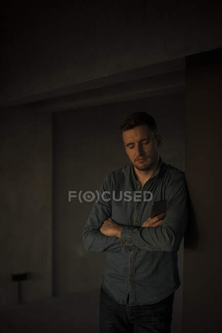 Exhausted businessman leaning on wall, with arms crossed — Stock Photo