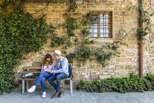 Young couple on a city break, sitting on a bench, taking a break — Stock Photo