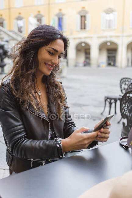 Jovem com xícara de café, usando smartphone — Fotografia de Stock