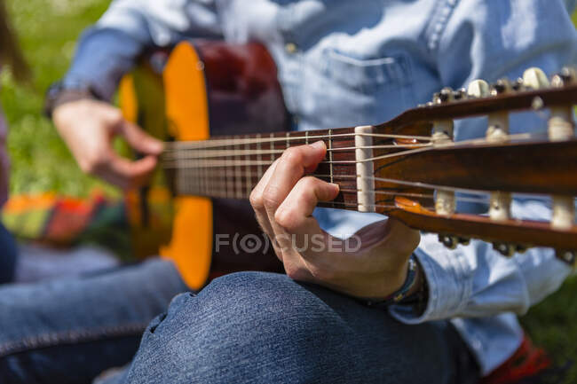 Giovane che suona la chitarra in un parco — Foto stock