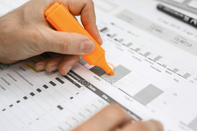 Close-up de empresário usando iluminador em um relatório na mesa no escritório — Fotografia de Stock