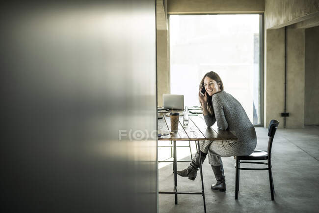 Жінка сидить на посаді, користуючись смартфоном. — стокове фото