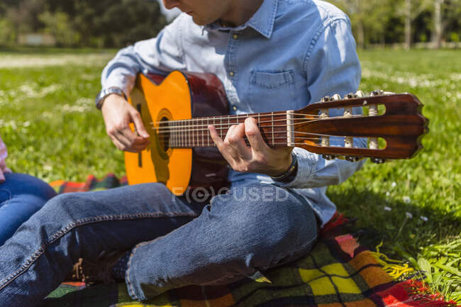 Giovane che suona la chitarra in un parco — Foto stock