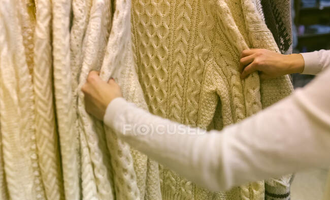 Close-up of woman shopping for a pullover in a vintage boutique — Stock Photo