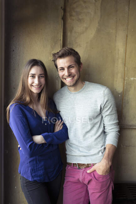 Ritratto di giovane coppia felice in piedi davanti a un muro — Foto stock