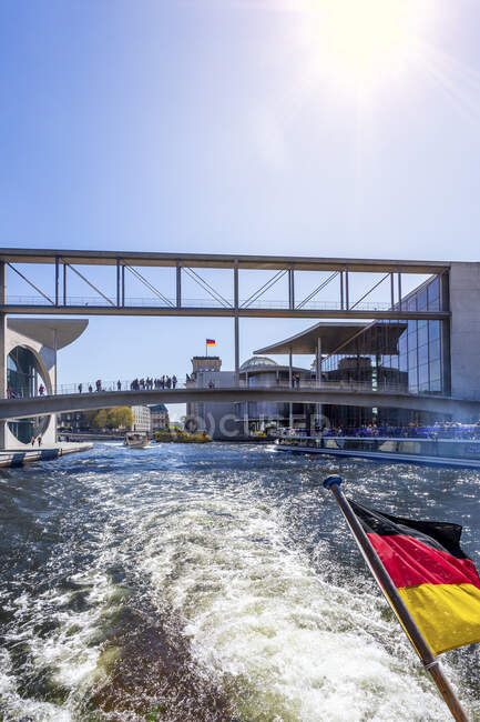 Alemania, Berlín, distrito gubernamental y bandera alemana en barco de excursión en el río Spree - foto de stock