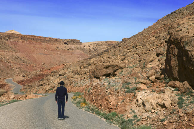 Marocco, Valle di Ounila, vista posteriore dell'uomo che indossa un cappello da bowler in piedi su strada in montagna — Foto stock