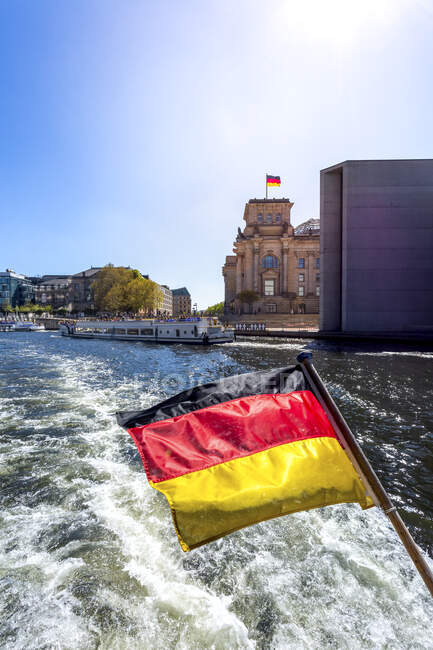 Alemania, Berlín, Reichstag y bandera alemana en barco de excursión en el río Spree - foto de stock