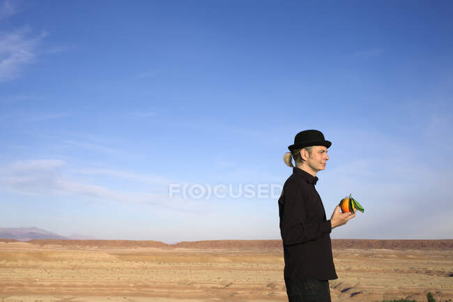Марокко, Долина Оуніла, чоловік у капелюсі з кашкетом, який тримає апельсин. — стокове фото
