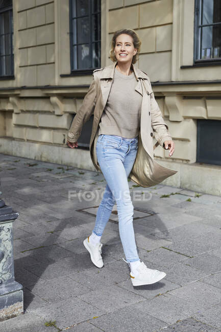 Happy woman walking on pavement in the city — Stock Photo