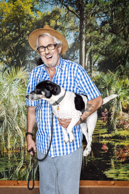 Älterer Mann mit Hut und Hund vor Fototapete — Stockfoto