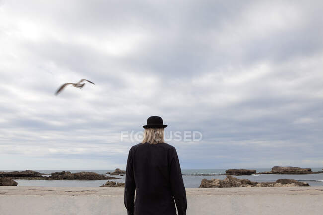 Marocco, Essaouira, vista posteriore dell'uomo che indossa un cappello a bombetta in piedi sul mare — Foto stock