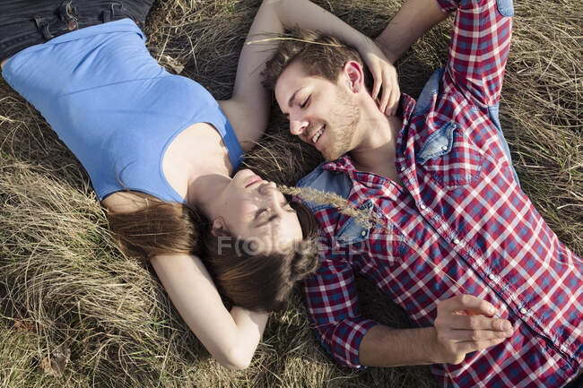 Щаслива молода пара лежить на лузі. — стокове фото
