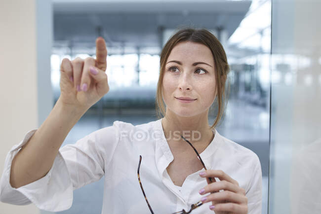 Giovane donna d'affari toccare touchscreen virtuale — Foto stock
