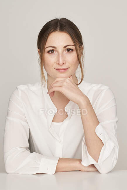 Портрет усміхненої молодої жінки у білій блузці. — стокове фото