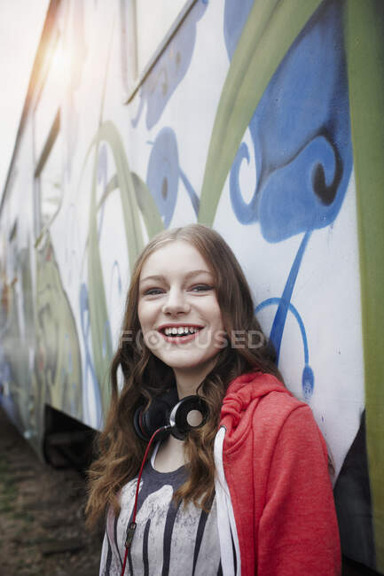 Портрет счастливой девочки-подростка у раскрашенного вагона — стоковое фото