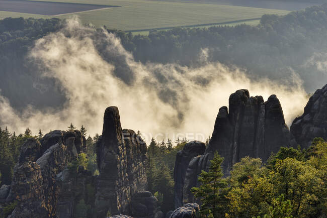 Germania, Sassonia, Elba Montagne di arenaria, rocce e aghi di roccia della Schrammsteine alla retroilluminazione — Foto stock