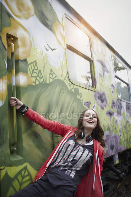 Retrato de una adolescente feliz en un vagón de tren pintado - foto de stock