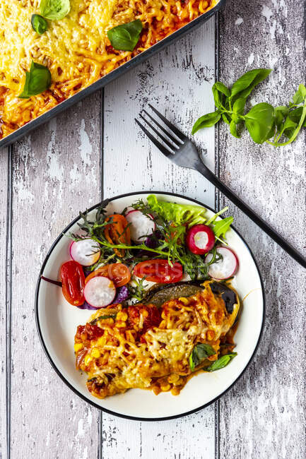 Aubergine lasagne on a plate with mixed salad — Stock Photo