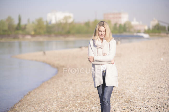 Mulher madura andando na beira do rio — Fotografia de Stock