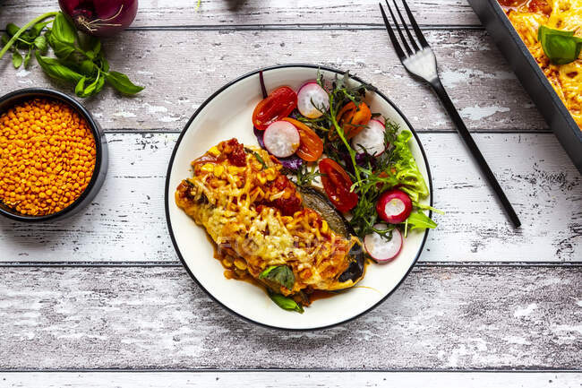 Aubergine lasagne on a plate with mixed salad — Stock Photo