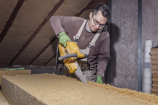 Roof insulation, worker placing wood fibre insulation at the roof — Stock Photo