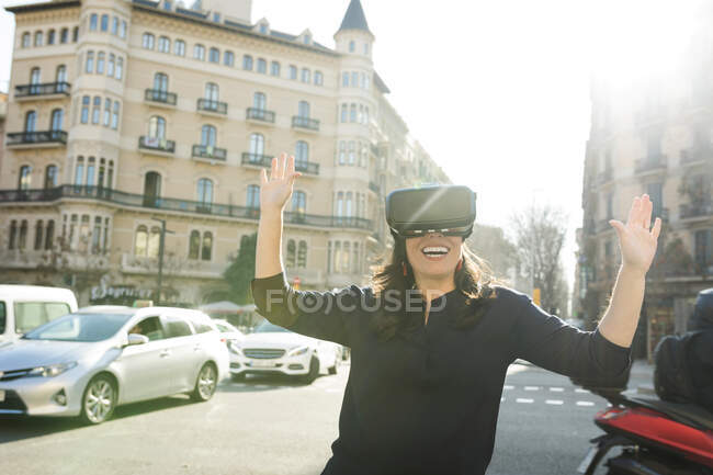 Mulher excitada vestindo óculos VR na cidade — Fotografia de Stock