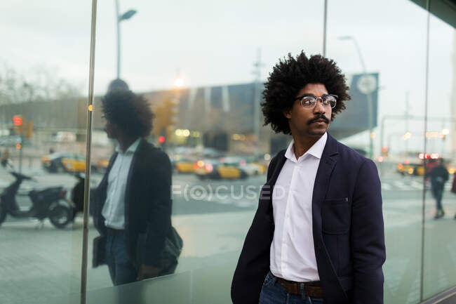 Spain, Barcelona, businessman on the move in the city reflected in glass front — Stock Photo