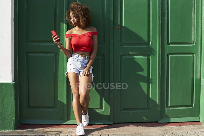 Mulher de vermelho verificando seu telefone — Fotografia de Stock