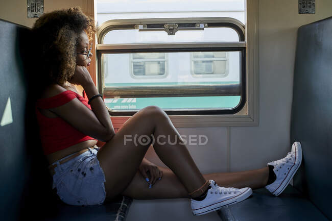 Молодая женщина в поезде смотрит в окно — стоковое фото