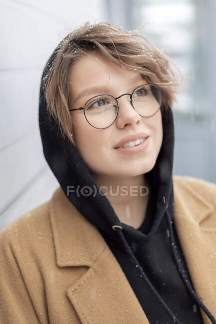 Portrait of young woman at snowfall — Stock Photo