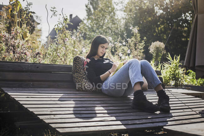Donna che si rilassa nel giardino urbano scrivendo nel quaderno — Foto stock