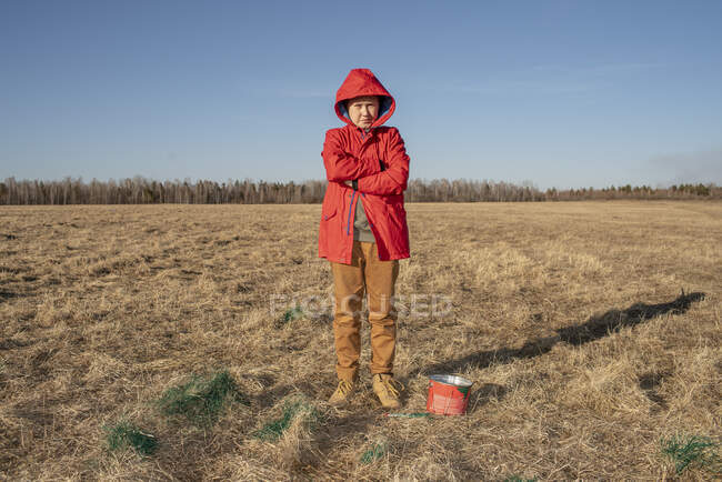 Rapaz sério com balde de tinta na paisagem estepe — Fotografia de Stock
