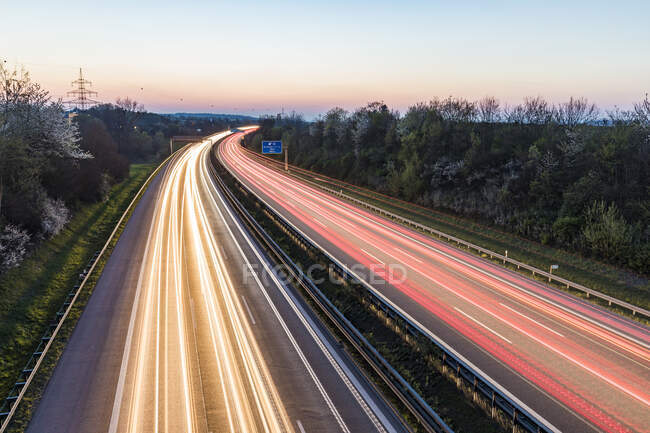 Germany, Baden-Wuerttemberg, traffic light trails on Autobahn A8 at dusk — Stock Photo