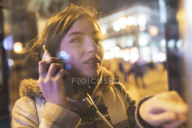 España, Madrid, joven en la ciudad usando una cabina telefónica - foto de stock